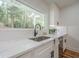 A kitchen sink with quartz countertops and a black faucet overlooking wooded outdoor scenery at 2729 Ridge Valley Nw Rd, Atlanta, GA 30327