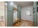Mudroom with sage green cabinets, wooden bench, neutral rug, and natural light entry door at 2729 Ridge Valley Nw Rd, Atlanta, GA 30327