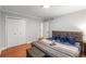 Bright bedroom featuring hardwood floors, a large bed, and closet for ample storage at 3307 Pointe Bleue Ct, Decatur, GA 30034