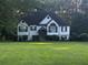 Charming two-story home featuring well-manicured lawn, black accents, and lush landscaping at 5022 Cliff Top Dr, Loganville, GA 30052