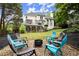 Inviting backyard featuring a fire pit with seating and a spacious lawn, perfect for outdoor gatherings at 6790 Wolford Ct, Johns Creek, GA 30097
