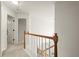 Bright hallway with carpet, white walls, and a wood and white railing at 6790 Wolford Ct, Johns Creek, GA 30097