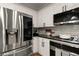 Modern kitchen featuring a stainless steel refrigerator, gas stovetop, and sleek white cabinetry at 6790 Wolford Ct, Johns Creek, GA 30097