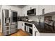 Well lit kitchen with stainless steel refrigerator, black countertops, and white cabinets at 6790 Wolford Ct, Johns Creek, GA 30097