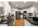 Modern kitchen with stainless steel appliances, granite countertops, white cabinets, and hardwood floors at 6790 Wolford Ct, Johns Creek, GA 30097