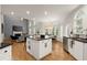 Inviting open-concept living space with kitchen island, fireplace, dining area and sun-filled windows at 6790 Wolford Ct, Johns Creek, GA 30097