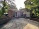 The backyard of the house with brick and siding is mostly concrete, with trees surrounding the area at 1247 Shoreham Dr, Atlanta, GA 30349