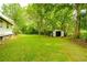 Expansive backyard featuring mature trees and an outbuilding at 1303 Cochise Cir, Austell, GA 30168