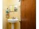 Bathroom with a pedestal sink, medicine cabinet, and wood door at 1303 Cochise Cir, Austell, GA 30168