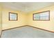 Neutral bedroom featuring carpet flooring, and two large windows at 1303 Cochise Cir, Austell, GA 30168