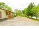Exterior view of the front yard featuring brick patio and lush trees surrounding the home at 1303 Cochise Cir, Austell, GA 30168