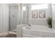 Relaxing bathroom with a separate shower and soaking tub, tile surround, and a window at 221 Begonia Way, Mcdonough, GA 30253