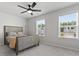 Modern bedroom showcasing a ceiling fan, two windows, and a stylish bed with neutral decor at 221 Begonia Way, Mcdonough, GA 30253