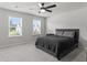 Modern bedroom with black bed, carpet flooring, two windows, and neutral walls at 221 Begonia Way, Mcdonough, GA 30253