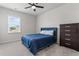 Cozy bedroom with a blue bed, carpet flooring, and a view of the neighborhood through the window at 221 Begonia Way, Mcdonough, GA 30253