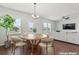 Bright breakfast nook with a round table, hardwood floors, and natural light flowing from adjacent living room at 221 Begonia Way, Mcdonough, GA 30253
