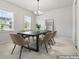 Formally staged dining room with natural light, a modern chandelier, neutral paint, and neutral-colored carpet at 221 Begonia Way, Mcdonough, GA 30253