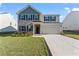Charming two-story home with brick and siding, a well-manicured lawn, and an attached two-car garage at 221 Begonia Way, Mcdonough, GA 30253