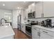 Well lit kitchen with white cabinetry, stainless steel appliances and a large island at 221 Begonia Way, Mcdonough, GA 30253