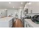 Beautiful open-concept kitchen with white cabinets, hardwood floors, stainless steel appliances, and a large island at 221 Begonia Way, Mcdonough, GA 30253