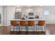 Modern kitchen with white cabinets, stainless steel appliances, a large island, and hardwood flooring at 221 Begonia Way, Mcdonough, GA 30253