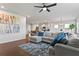 Bright, open living room featuring a large sectional sofa and hardwood floors that flows into the kitchen at 221 Begonia Way, Mcdonough, GA 30253