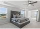 Spacious main bedroom features a bed, tray ceiling, two windows, and a full-length mirror at 221 Begonia Way, Mcdonough, GA 30253