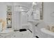 Elegant bathroom featuring a pedestal sink, shower, and built-in shelving for storage and display at 3143 Denton Ne Pl, Roswell, GA 30075