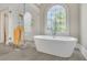 Luxurious bathroom features a standalone tub and a decorative arched window at 3143 Denton Ne Pl, Roswell, GA 30075