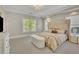 Well-lit bedroom with a large window, a decorative bench, and modern furnishings at 3143 Denton Ne Pl, Roswell, GA 30075