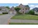 Charming two-story brick home with an attached two-car garage and a well-manicured lawn at 3143 Denton Ne Pl, Roswell, GA 30075