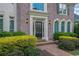 Elegant brick home entrance featuring a black door, manicured bushes, and a brick walkway at 3143 Denton Ne Pl, Roswell, GA 30075