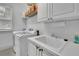 Neat laundry room with utility sink and storage shelves at 3143 Denton Ne Pl, Roswell, GA 30075