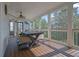 Beautiful screened porch with wooden floors, ceiling fan, and an outdoor dining table at 3143 Denton Ne Pl, Roswell, GA 30075