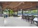 Outdoor entertainment area with ceiling fans and bar overlooking tennis court at 320 Harvest View Ter, Woodstock, GA 30188