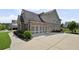 A beautiful home featuring an attached three-car garage and neutral color scheme with landscaped yard at 320 Harvest View Ter, Woodstock, GA 30188