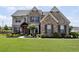 Charming two-story home with stone and brick facade, landscaped front yard, and decorative shutters at 320 Harvest View Ter, Woodstock, GA 30188