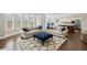 Open concept living room flowing into a kitchen area with hardwood floors, neutral tones and large windows at 320 Harvest View Ter, Woodstock, GA 30188