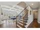 Bright living room featuring hardwood floors, coffered ceilings, and a staircase with iron spindles at 320 Harvest View Ter, Woodstock, GA 30188