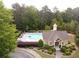 Aerial view of the community pool showcasing the pool house, lush landscaping, and nearby trees at 4769 Moon Hollow Ct, Buford, GA 30519