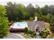 Aerial view of a community pool with lounge chairs and a pool house, surrounded by trees at 4769 Moon Hollow Ct, Buford, GA 30519