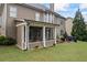 Spacious backyard features a screened porch, outdoor patio with kitchen, seating and a neatly manicured lawn at 4769 Moon Hollow Ct, Buford, GA 30519