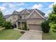 Charming two-story brick home featuring a two-car garage, well-manicured lawn, and professional landscaping at 4769 Moon Hollow Ct, Buford, GA 30519