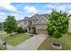 Two-story home with brick and siding exterior, manicured lawn, mature trees, and attached garage at 4769 Moon Hollow Ct, Buford, GA 30519