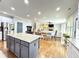 Open-concept kitchen featuring an island with granite counters, stainless steel appliances, and hardwood floors at 4769 Moon Hollow Ct, Buford, GA 30519