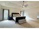 Spacious bedroom featuring tray ceilings, ceiling fan, and large windows with natural light at 4769 Moon Hollow Ct, Buford, GA 30519