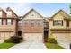 Charming brick townhome featuring a two-car garage and manicured front lawn at 1539 Creek Bend Ln, Lawrenceville, GA 30043