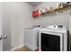 Functional laundry room equipped with modern washer and dryer units, plus shelving for storage at 1539 Creek Bend Ln, Lawrenceville, GA 30043