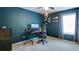 Well-lit bedroom featuring a neutral carpet, sleek black desk, and dark blue accent wall, creating a modern and inviting workspace at 156 Woodhouse Cir, Acworth, GA 30102