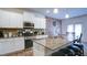 Elegant kitchen featuring granite countertops, stainless steel appliances, and a center island with barstool seating at 156 Woodhouse Cir, Acworth, GA 30102